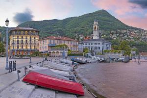 una barca rossa adagiata sul bordo di uno specchio d'acqua di That's Amore Cernobbio - Lake Como Apartment a Cernobbio