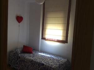 una habitación con un globo de corazón rojo y una ventana en Javier Hidalgo, en Granada