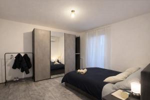 una camera da letto con un letto grande e uno specchio di That's Amore Cernobbio - Lake Como Apartment a Cernobbio