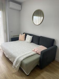a blue couch with pillows on it in a room at Acogedor apartamento Vallparadís con parking in Terrassa