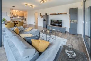 a living room with a blue couch and a tv at Konny in Gaienhofen