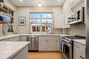 a kitchen with white cabinets and a large window at Tremblant Prestige - Les Eaux 221-3 in Mont-Tremblant