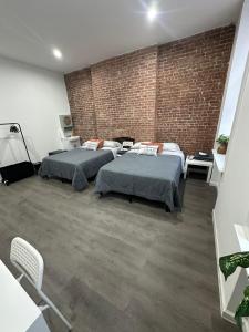 2 letti in una camera con muro di mattoni di Aycee 417 a New York