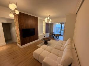 ein Wohnzimmer mit einem großen Sofa und einem TV in der Unterkunft Baneasa Panorama Lake in Bukarest