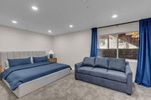 a bedroom with a bed and a couch and a window at Lehi High Luxe Views and Sky in Lehi +47 photos