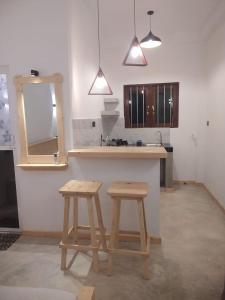 a kitchen with two wooden stools in front of a counter at Isurindi Villa in Midigama East +90 photos