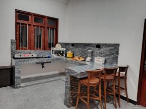 a kitchen with a counter and two bar stools at Isurindi Villa in Midigama East