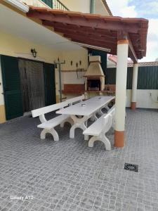 un gruppo di tavoli da picnic su un patio di Marcio's Home a Fernão Ferro