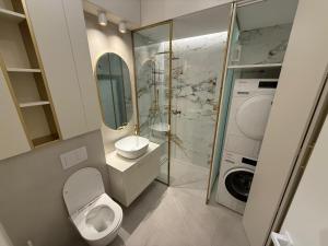 ein Badezimmer mit Toilette, Waschbecken und Waschmaschine in der Unterkunft Baneasa Panorama Lake in Bukarest + 19 Fotos