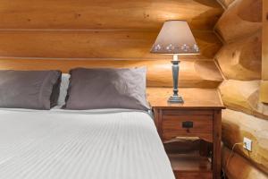 a bedroom with a bed and a lamp on a table at Rustic Chalet Perfect Getaway for Groups in Golden