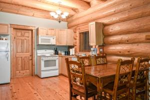 a kitchen with a table and a stove top oven at Authentic, Timber Log Cabin Perfect for Groups in Golden +14 photos