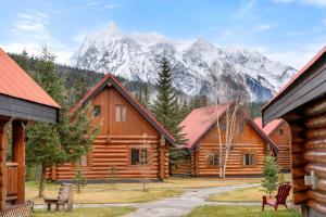 a log cabin with mountains in the background at Rustic Cabin Hideaway with BBQ Fire Pit and Mtn Views in Golden