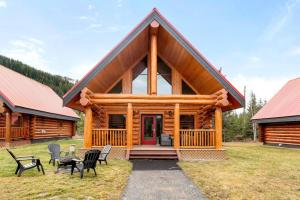 a log cabin with chairs and tables in front of it at Rustic Cabin Hideaway with BBQ Fire Pit and Mtn Views in Golden