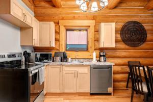 a kitchen with a stove and a sink in a cabin at Rustic Cabin Hideaway with BBQ Fire Pit and Mtn Views in Golden