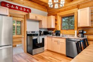 a kitchen with stainless steel appliances and wooden cabinets at Rustic Cabin Hideaway with BBQ Fire Pit and Mtn Views in Golden +28 photos
