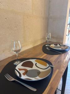 een tafel met een bord en twee glazen erop bij Résidence ARTHUS Cinopé in Pierrefonds +19 foto's