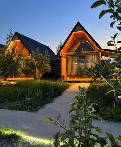 een houten huis met een pad ervoor bij Coral houses in Tossor