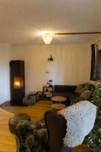a living room with a christmas tree and a couch at Chalet Alpl - Ferienwohnung Waldblick mit Sauna, Kamin & Whirlwanne in Hochrindl