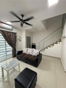 een woonkamer met een bank en een plafondventilator bij De Little Cabin - 7mins to Sunway Iost World of Tambun in Ipoh