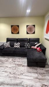 a black couch in a living room with pillows on it at El RINCONCITO in Mahora +8 photos