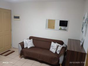 伊洛伊洛One Spatial-Iloilo Condo B2U2220的客厅配有棕色的沙发和镜子