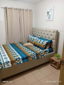 伊洛伊洛One Spatial-Iloilo Condo B2U2220的一间卧室，里面有一张床，铺着蓝色被子。