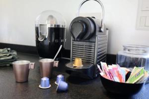 een aanrecht met een koffiezetapparaat en kopjes erop bij NEW - Maison brique 4p - Côte Pavée coeur Toulouse in Toulouse