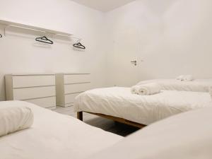 twee bedden in een kamer met witte muren bij Kölner Street Loft ,Neu Renoviert für bis zu 5 Personen mit Küche und Bad in Düsseldorf