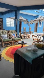 una stanza con sedie, tavoli e ombrelloni di Pousada Mar e Sol a Peruíbe