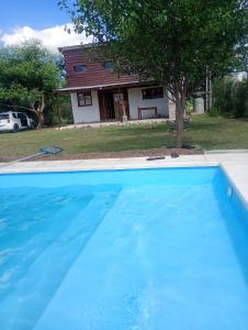 una grande piscina blu davanti a una casa di Cabaña Mitimay ad Alta Gracia