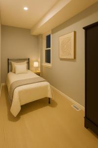 una camera da letto con un letto e un quadro sul muro di Fully Equipped 3 Beds Apartment, 5 min from the Arch a Saint Louis