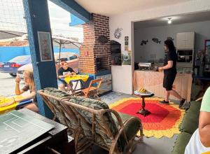 a group of people sitting at a table in a kitchen at Pousada Mar e Sol in Peruíbe