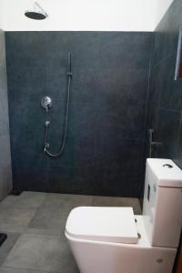een badkamer met een wit toilet en een douche bij Villa NU 380 in Galle