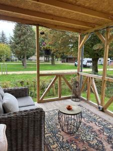 eine abgeschirmte Veranda mit einem Sofa und einem Tisch in der Unterkunft Het Heideverblijf in Heerlen