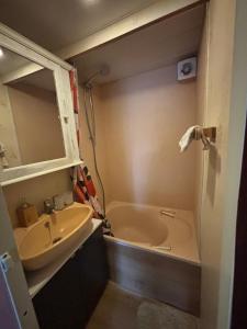 a small bathroom with a sink and a tub at Het Heideverblijf in Heerlen