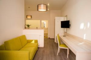 a living room with a yellow couch and a table at Hotel Fürsteneck in Bernburg