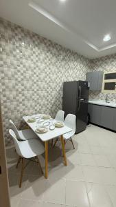a dining room with a table and white chairs at شقة بطابع أنيق in Al Kharj +17 photos