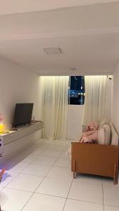 a living room with a bed and a flat screen tv at Apt 424 in João Pessoa