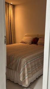 a bedroom with a large bed with a window at Apt 424 in João Pessoa +4 photos
