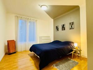 ein Schlafzimmer mit einem blauen Bett und einem Fenster in der Unterkunft Beauséjour in Saint-Herblain