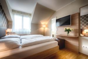 a bedroom with a large bed and a flat screen tv at Dom Hotel in Gescher