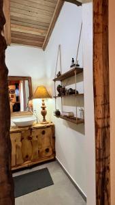 a room with a table with a lamp on a dresser at Casa Refúgio com suíte e lareira! in São Miguel da Serra +14 photos