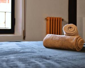ein rollendes Handtuch auf dem Bett in der Unterkunft Appartamenti "UNIQUE" palazzo storico FAENZA in Faenza + 23 Fotos