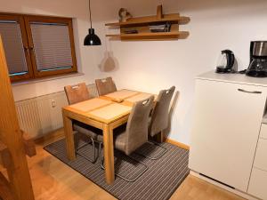 una cucina con tavolo, sedie e frigorifero di Kuckucksnest a Ühlingen-Birkendorf