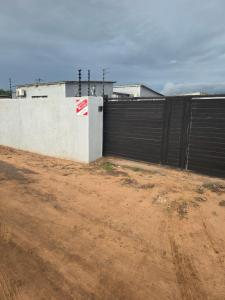 una recinzione accanto a una strada sterrata accanto a un edificio di Bill's villa a Lothlekane