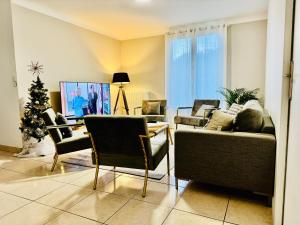 ein Wohnzimmer mit Sofas und einem Weihnachtsbaum in der Unterkunft Beauséjour in Saint-Herblain