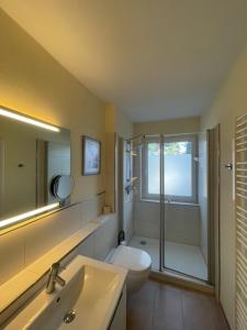 a bathroom with a toilet and a sink and a shower at Seepferdchen in Timmendorfer Strand +48 photos