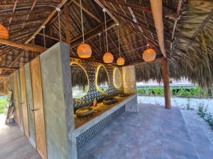 un ristorante con diverse luci appese a un tetto di paglia di Dos Peladas Hostal a Santa Marta