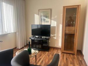 a living room with a television and a glass table at Seepferdchen in Timmendorfer Strand
