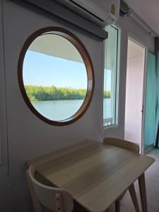 - une salle à manger avec une table et un miroir rond dans l'établissement Madee House - มาดีเฮ้าส์, 